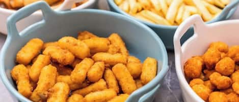 Bowls of food items, including tater tots and French fries.