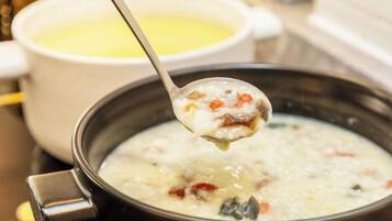 A spoonful of soup being lifted from a pot.