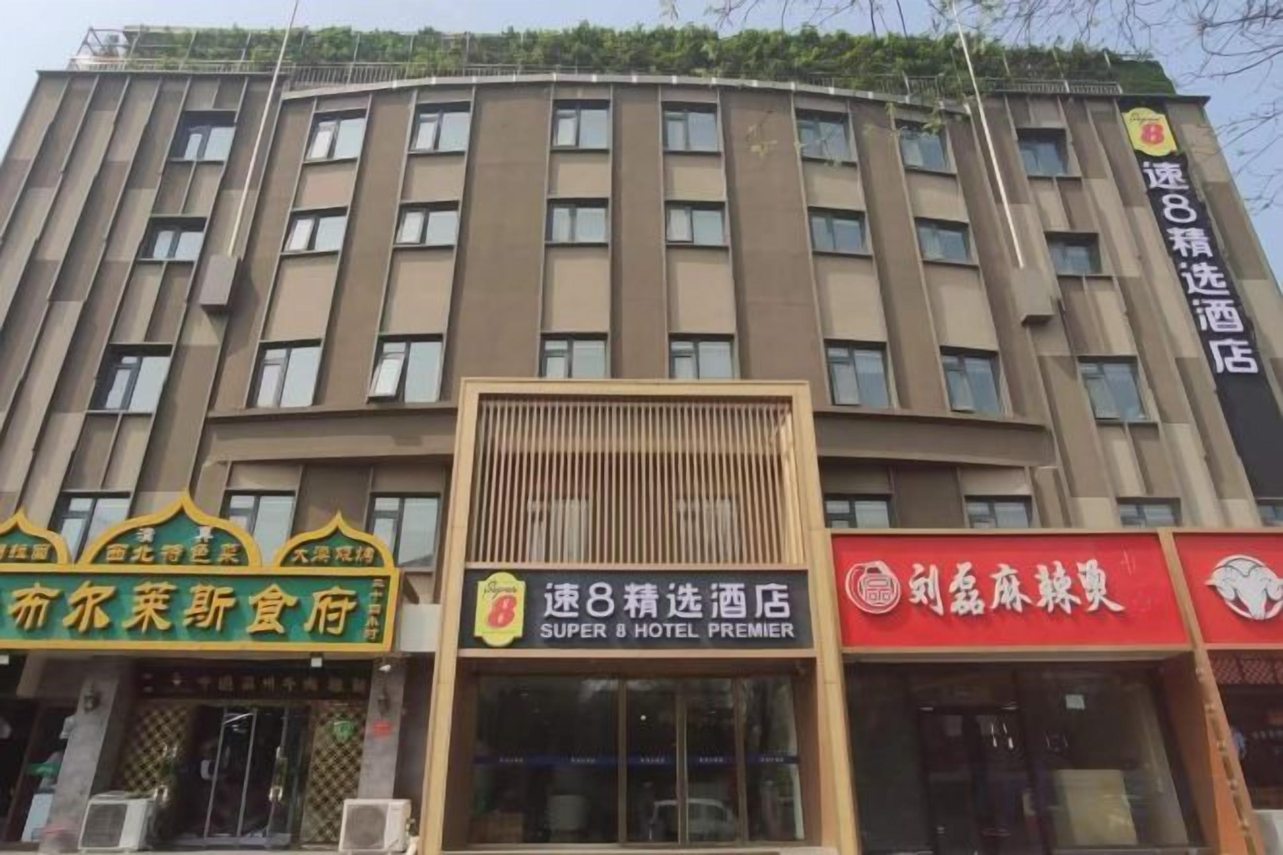Un edificio de hotel de varios pisos con señalización para un restaurante y un hotel.