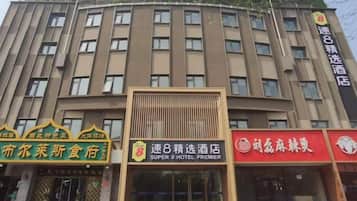 Un edificio de hotel de varios pisos con señalización para un restaurante y un hotel.