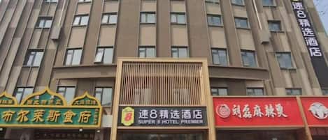A multi-story hotel building with signage for a restaurant and a hotel.