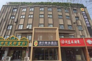 Un edificio de hotel de varios pisos con señalización para un restaurante y un hotel.