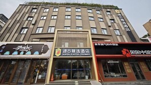 Un hôtel à l’architecture moderne, avec une façade remarquable, sur laquelle on peut voir une grande enseigne indiquant « Super 8 Hotel Premier » et une autre indiquant « Juny China ».