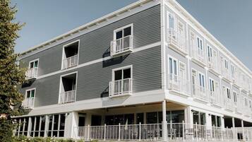 Un immeuble à plusieurs étages doté de balcons et d’un porche avant couvert.