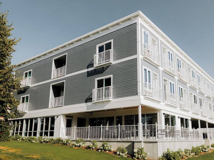 Un immeuble à plusieurs étages doté de balcons et d’un porche avant couvert.