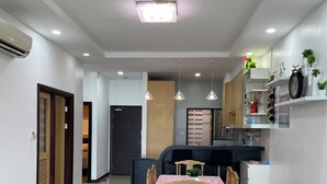 A modern kitchen with a built-in stove, a dining area with a table and chairs, and a ceiling fan. - Spacious 3-bedroom apartment with AC, fitness room in charming Kuching (Kuching)