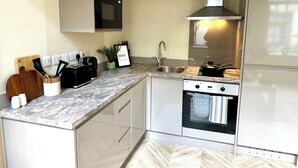 Una cocina moderna con horno empotrado, microondas y refrigerador de acero inoxidable.