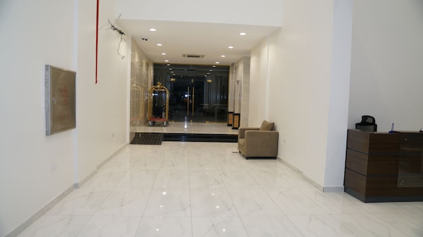 A modern lobby with a clean, polished floor, a seating area, and a reception desk. - Onesen Serviced Apartments 4 (Dammam)