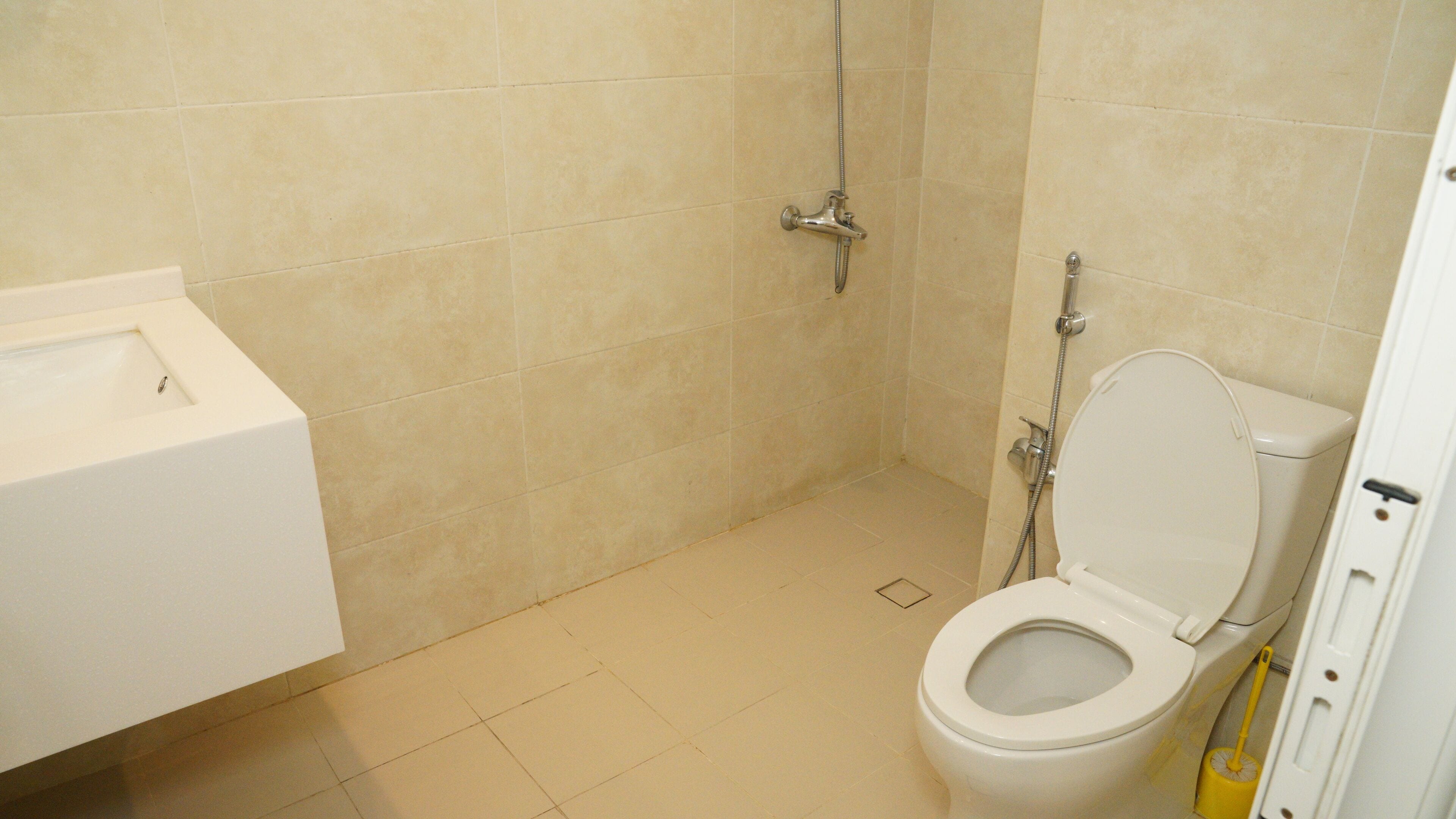 A bathroom with a toilet, a shower, and a sink.