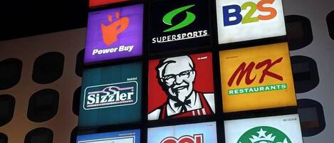 Un cartel con varios logotipos de marca, incluyendo Robinson Lifestyle, Tops, Power Buy, SuperSports, B2S, Sizzler, KFC, MKT Restaurants, Fuji y Go! Hotel.