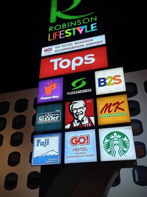 A signboard with various brand logos including Robinson Lifestyle, Tops, Power Buy, SuperSports, B2S, Sizzler, KFC, MKT Restaurants, Fuji, and Go! Hotel. - NOPPHADON HOTEL (Bangkok)