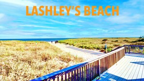 A beach scene with a wooden boardwalk and the text "Lashley's Beach". - 5 Bedrooms! 4 Min to the Beach! HEATED POOL! (Westhampton Beach)