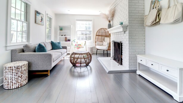 A modern living room with a grey sofa, round coffee table, and a white fireplace. - 5 Bedrooms! 4 Min to the Beach! HEATED POOL! (Westhampton Beach)