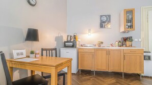 Una cocina compacta con una mesa de comedor, sillas, microondas y armarios de madera.