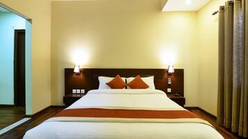 Een hotelkamer met een groot bed, twee nachtkastjes, een spiegel.