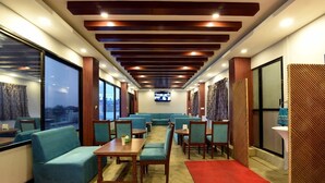 A modern lounge area with seating, a television, and a city view. - Hotel Harmony (Kathmandu)