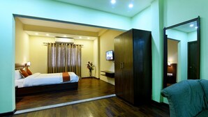A hotel room with a bed, a TV, a wardrobe, and a mirror. - Hotel Harmony (Kathmandu)