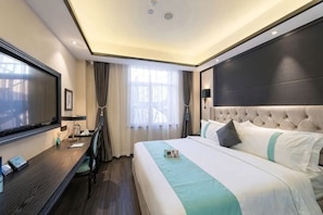 A hotel room with a large bed, a desk, a flat-screen TV, and a window with curtains. - Xana Hotelle (Beijing Changping Metro Station, China University of Petroleum‑Beijing) (Beijing)