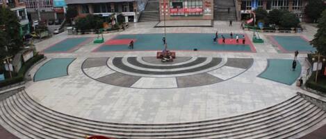 Una plaza pública con un monumento central, escalones que conducen al monumento y edificios circundantes.