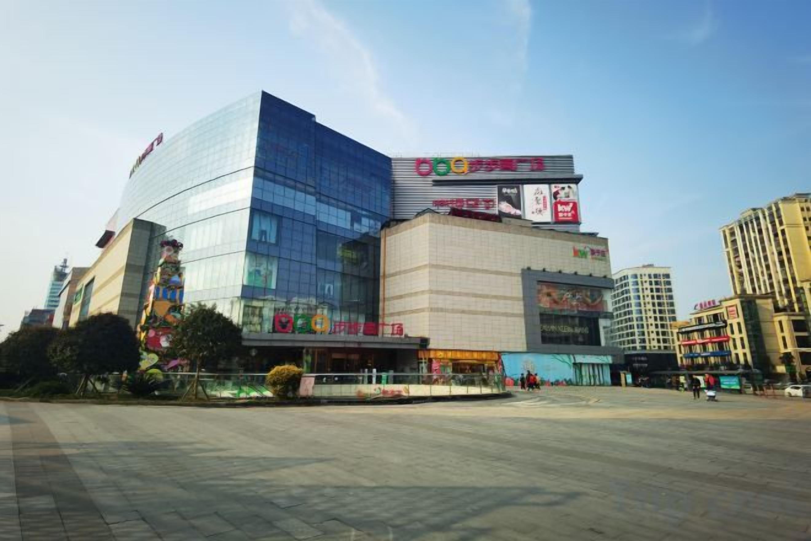 Un edificio moderno con fachada de vidrio y señalización que indica una zona comercial.