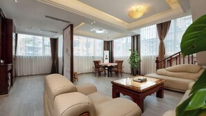 Un salon spacieux comprenant un canapé, une table basse et un coin repas avec des chaises.