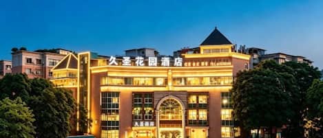 A hotel with a prominent entrance, multiple floors, and a well-lit facade.
