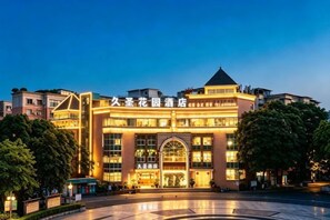Een hotel met een opvallende ingang, meerdere verdiepingen en een goed verlichte gevel.