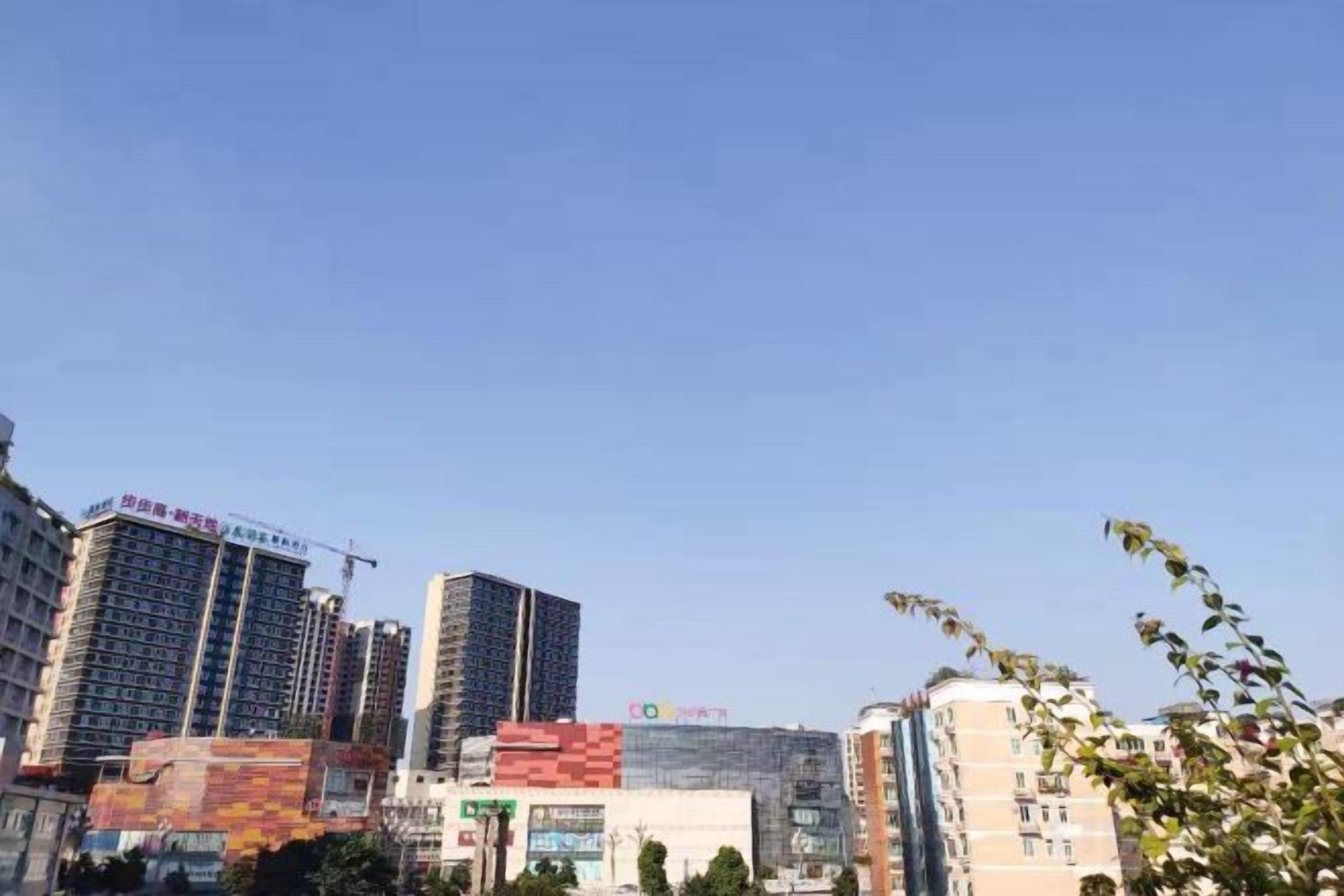Paisagem urbana com edifícios altos, incluindo um hotel com placa chamativa.