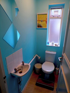 A small bathroom with a sink, toilet, and window. - Santoriniapartmentwestkensingtonsleeps3-ensuite-ac (London)