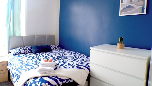 A bedroom with a bed, a dresser, a window with curtains, and a painting on the wall. - Santoriniapartmentwestkensingtonsleeps3-ensuite-ac (London)
