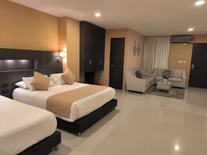 A modern hotel room with a large bed, a sofa, and a small table. - Hotel Quarta Avenida (Montería)