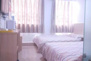 A bedroom with two beds, a desk, and a window with curtains. - Dingding Hotel (Shanghai New International Expo Center Huaxia East Road Subway Station) (Shanghai)