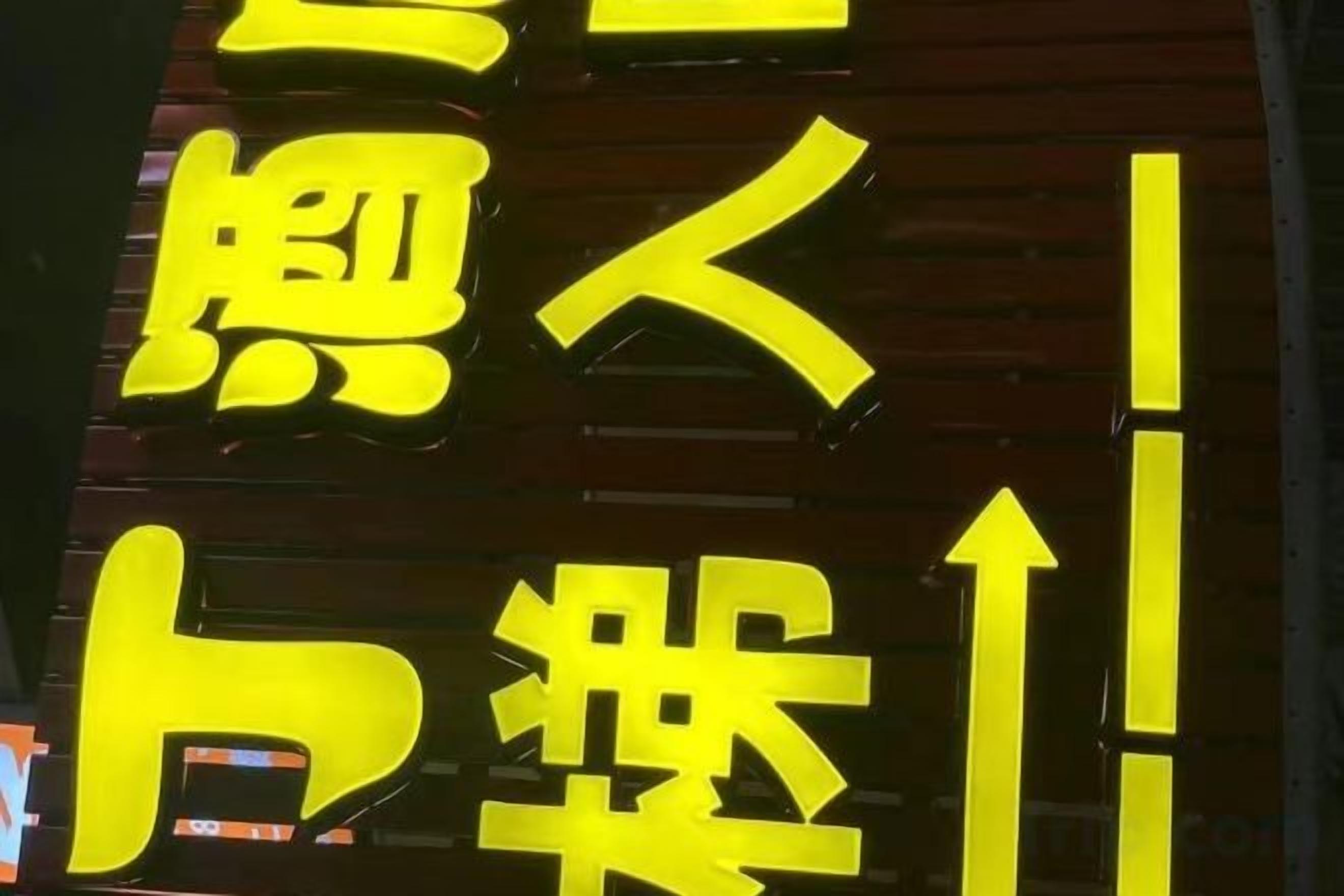 A sign with large yellow characters on a dark background.