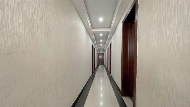 A long, narrow hallway with a tiled floor and white walls.