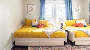 Un dormitorio con dos camas, cada una con ropa de cama amarilla y cojines decorativos.