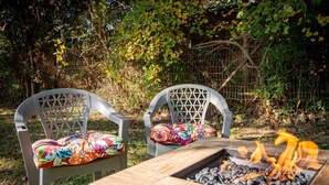 Two outdoor chairs with floral cushions, a wooden table, and a charcoal fire. - Urban Haven -Glen Iris/2 BR/Pets/WiFi/Full Kitchen (Birmingham)