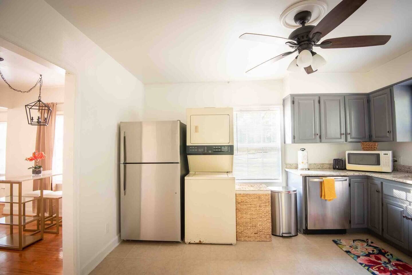A compact kitchen with a refrigerator, microwave, and a ceiling fan.