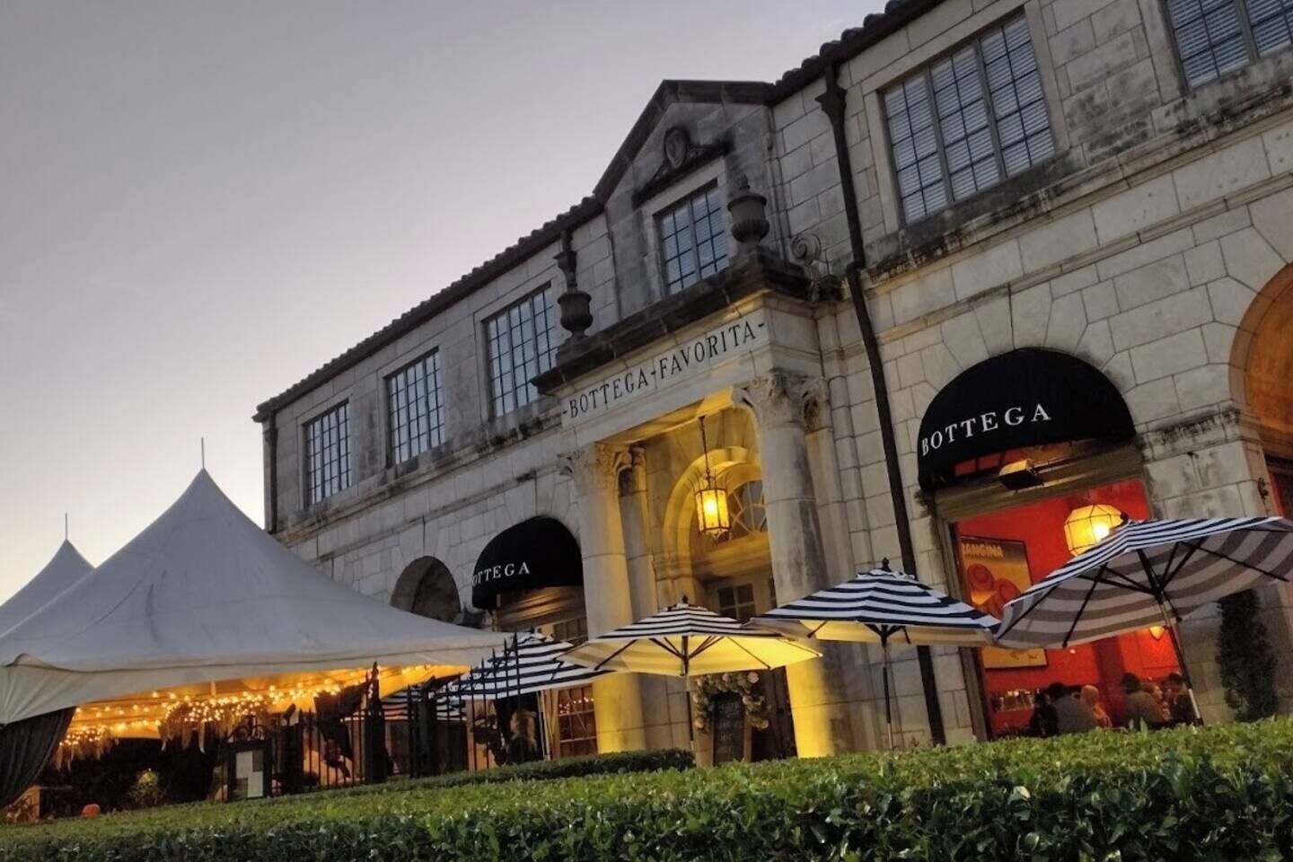 A historic building with arched entrances and a sign reading "Bottega."