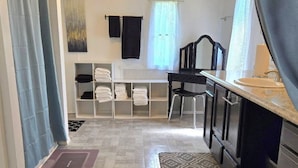 A compact kitchen with a countertop, a sink, and a chair. There are towels hanging on a rack and a rug on the floor. - Affordable Pollyanna Ridge, By Norris Lake & Dam St Pk & ATV trails. 3BR 2Bath (Rocky Top)