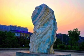 A large rock sculpture in an outdoor setting with buildings in the background. - Henghui Binle Hotel (Shijiazhuang Zhonghua North Street Branch) (Shijiazhuang)