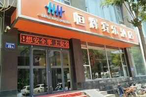 A building with a large orange awning and a sign that reads 'Longquan Qijiao'. - Henghui Binle Hotel (Shijiazhuang Zhonghua North Street Branch) (Shijiazhuang)