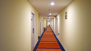 A long, narrow hotel corridor with a striped carpet and doors on both sides. - Henghui Binle Hotel (Shijiazhuang Zhonghua North Street Branch) (Shijiazhuang)