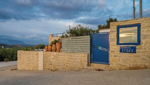 Un muro de piedra con una reja azul, plantas en macetas y un letrero que dice 'HOUSE STAKS'.