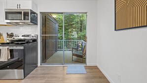 Eine moderne Küche mit einer Schiebeglastür, die auf einen Balkon führt.