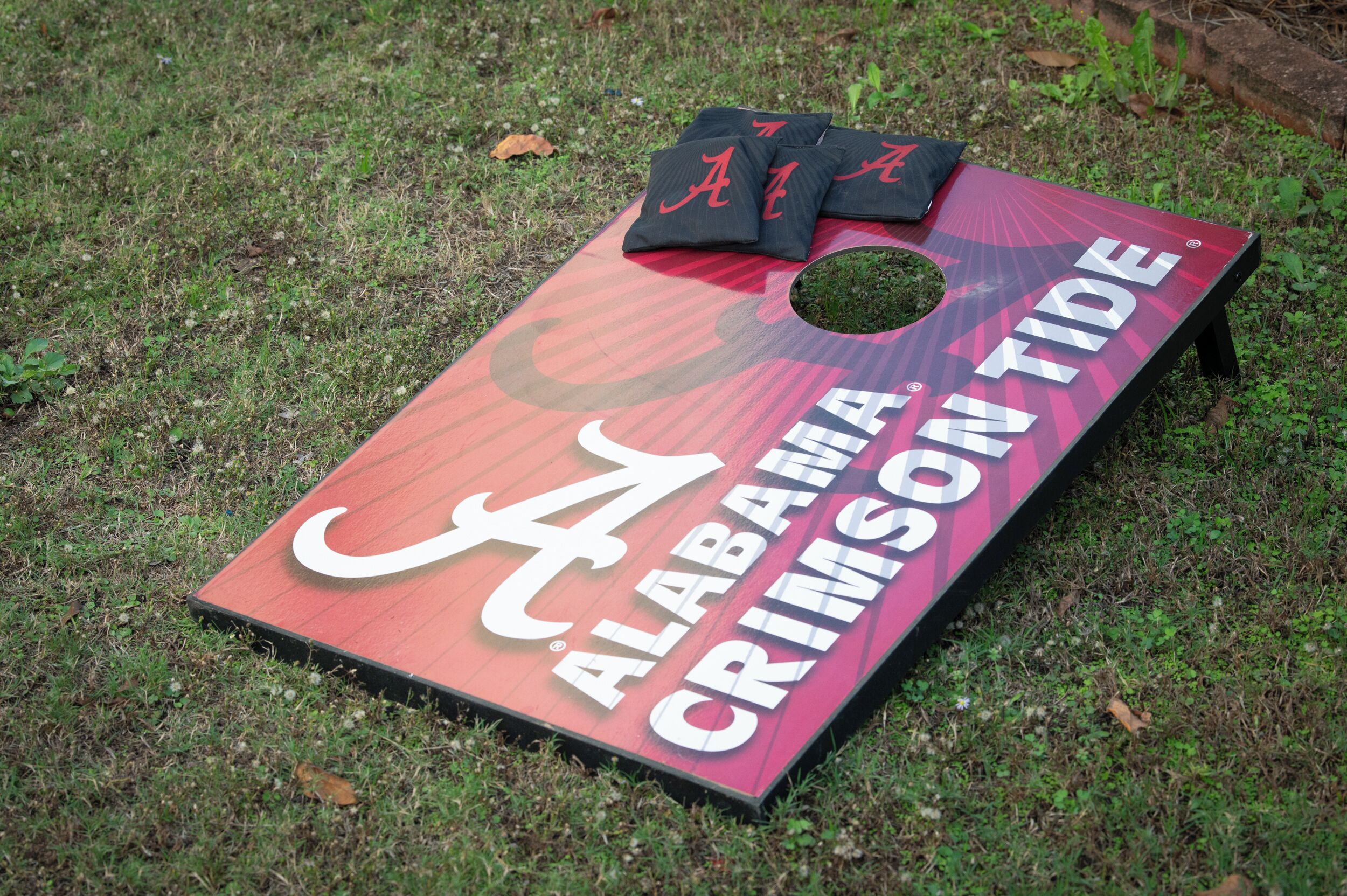 Un jeu de société intitulé « Alabama Crimson Tide », joué sur de l’herbe.