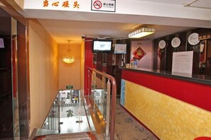 A hotel lobby with a reception desk, a staircase, and a chandelier. - Jinghe Hostel (Shanghai)