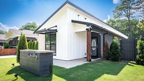 Een modern huis met een witte gevel, een garage en een verzorgd gazon.