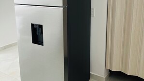 Ein Edelstahl-Kühlschrank mit Gefrierfach oben, Wasserspender und integriertem Eisbereiter.