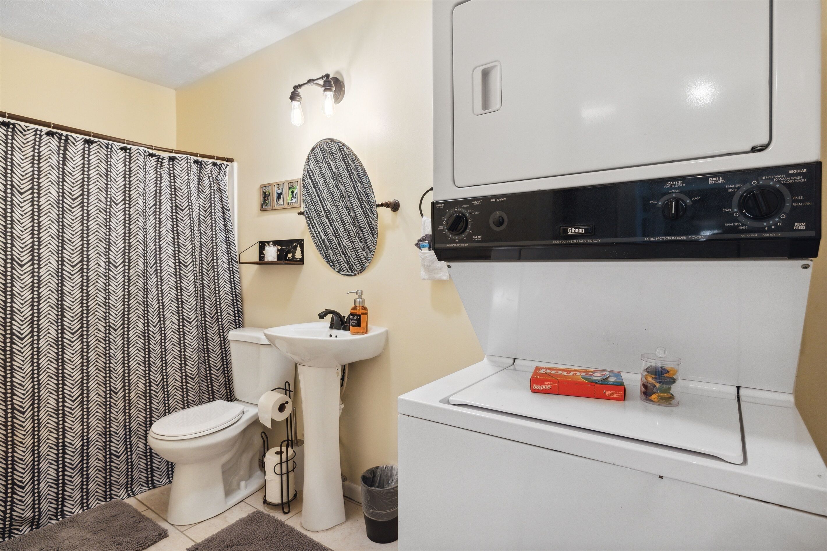 A bathroom with a toilet, sink, and a washing machine.