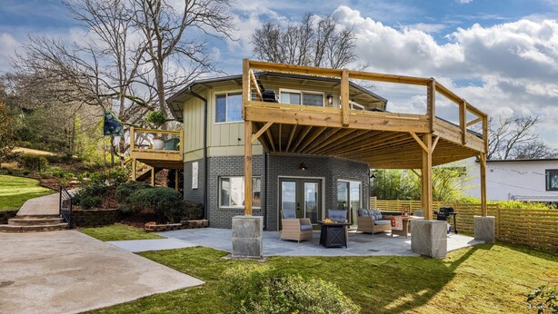A two-story house with a wooden deck and a covered patio area. - The Hobbit House - City Views/Deck & Patio/Firepit (birmingham)